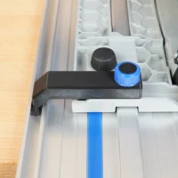 Anti-Tip Guide for Kreg ACS track saw mounted on aluminum rail, showing black PETG body with blue adjustment knob and black knob