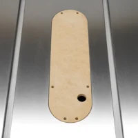 Beige MDF zero clearance insert for SawStop table saw, shown from above with four mounting holes and one center opening