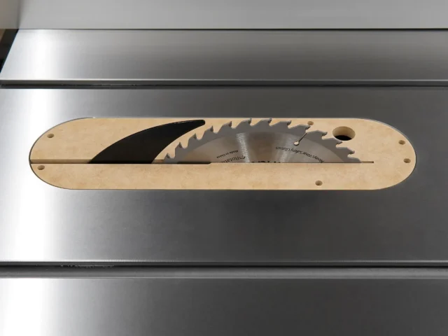 Light wood MDF insert with curved edges and mounting holes, containing two saw blades in a horizontal slot