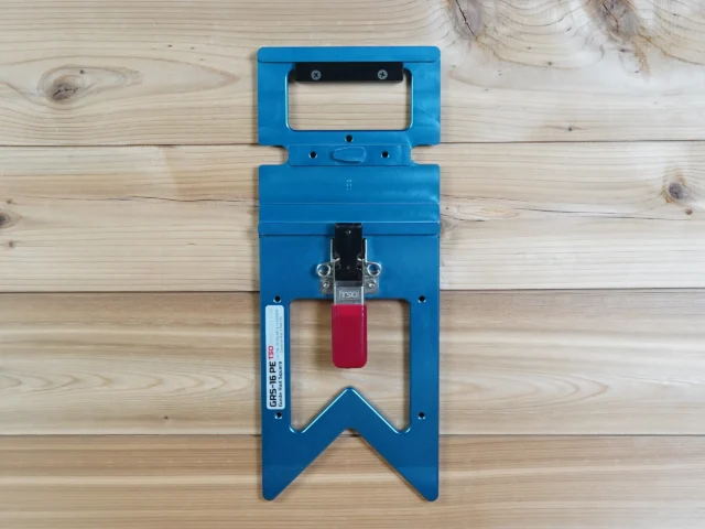 Blue wall mount holder with red clamp lever, designed to hold a Festool guide rail square vertically on a shop wall or cabinet
