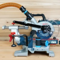 Black 1-1/4" hose adapter with blue bands joining an orange vacuum hose to a Bosch 18v miter saw dust port