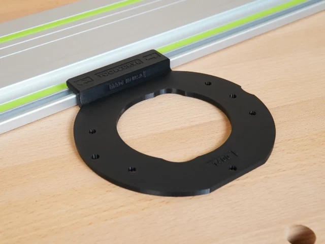 Black circular adapter with mounting holes, attached to a Festool guide rail with lime-green stripe