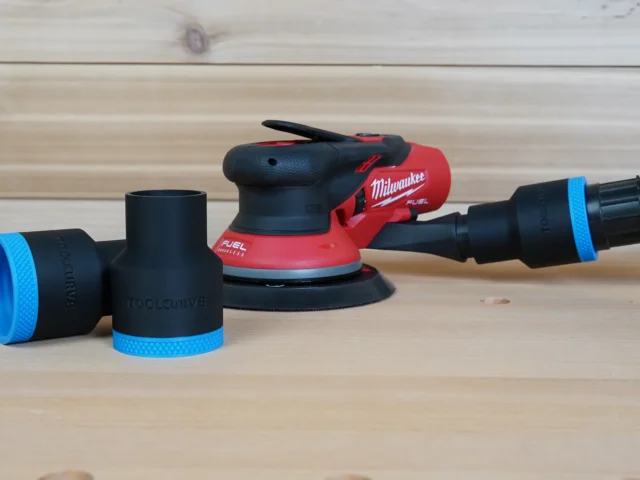Black ToolCurve 1-7/8 inch hose adapter with blue collar beside a Milwaukee M12 random orbit sander
