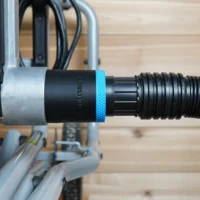 Black ToolCurve 1-7/8 inch hose adapter with blue ring joining a ribbed shop vac hose to a Kobalt table saw dust port