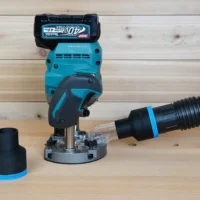 Black 2-1/2 inch ToolCurve hose adapter with blue ring joining a vac hose to a Makita 40v XGT plunge router, second adapter beside it