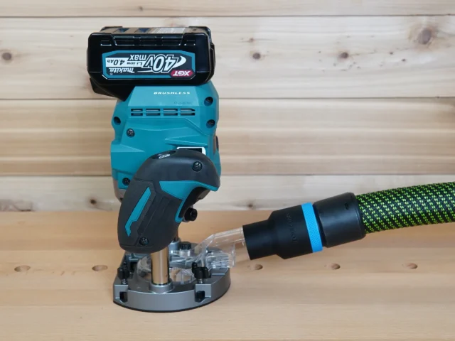 Black 36mm hose adapter with blue band joining a green hose to a Makita 40v XGT plunge router dust port