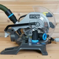 Black 36mm ToolCurve hose adapter with blue collar fitted to the dust port of a Ryobi 10-inch miter saw