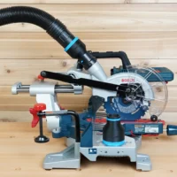 Black 2-1/2 inch hose adapter with blue band linking a ribbed vacuum hose to a Bosch 18v miter saw dust port