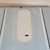 Dado zero clearance MDF insert seated flush in a Kobalt 10-inch table saw top, uncut with four leveling screw holes