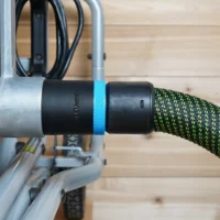 Black 36mm hose adapter with blue band joining a green vacuum hose to a Kobalt table saw dust port
