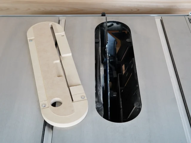 Zero clearance insert for Kobalt 10″ table saw shown in natural and black variants, displayed on a track with metal rails.