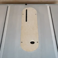 Zero clearance insert for Kobalt table saw, installed in saw table with centered blade slot and oval dust port visible