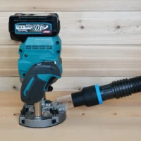 Black 1-7/8 inch hose adapter with blue band joining a vacuum hose to a Makita 40v XGT plunge router dust port