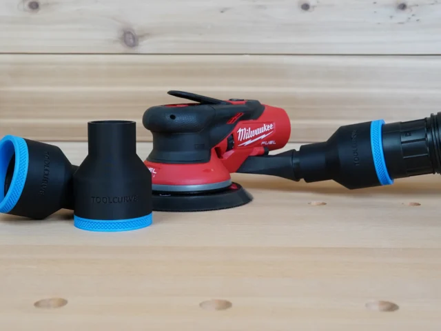 Black ToolCurve 2-1/2 inch hose adapters with blue rings beside a Milwaukee M12 sander, one joined to a vac hose