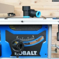 ToolCurve hose adapter with blue and black bands mounted on Kobalt table saw dust port