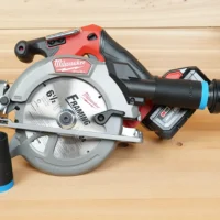 Black 1-1/4 inch hose adapter with blue band installed on a Milwaukee M18 circular saw dust port, second adapter beside it