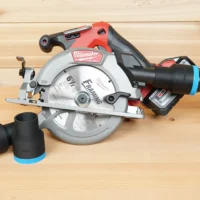 Black 1-7/8 inch ToolCurve hose adapter with blue band installed on a Milwaukee M18 circular saw dust port, second adapter beside it