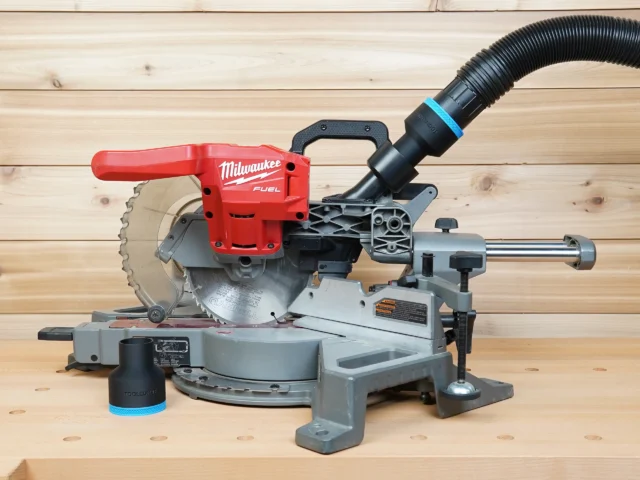 Black ToolCurve 2-1/2" hose adapter with blue band on a Milwaukee miter saw dust port, second adapter beside it