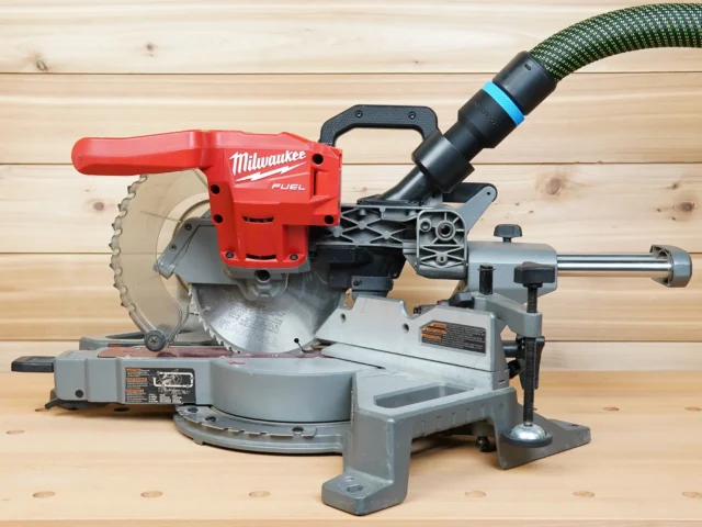 Black 36mm hose adapter with blue band joining an extractor hose to a Milwaukee 7-1/4" miter saw dust port