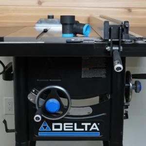 Black ToolCurve elbow hose adapter with blue cuffs resting on the cast iron top of a Delta table saw