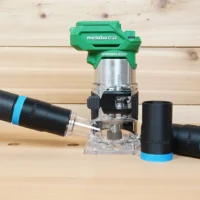 Black ToolCurve hose adapter with blue band joining a vacuum hose to a green Metabo HPT trim router, two spare adapters beside it