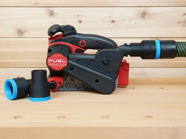 Black 36mm ToolCurve hose adapter with blue band on a Milwaukee M18 belt sander, second adapter beside it