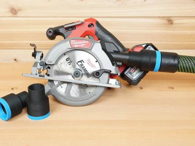 Black 36mm hose adapter with blue band installed on a Milwaukee M18 circular saw dust port, spare adapters alongside