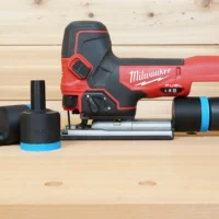 Black 36mm ToolCurve hose adapter with blue band beside a Milwaukee M18 Fuel jig saw, second adapter on hose