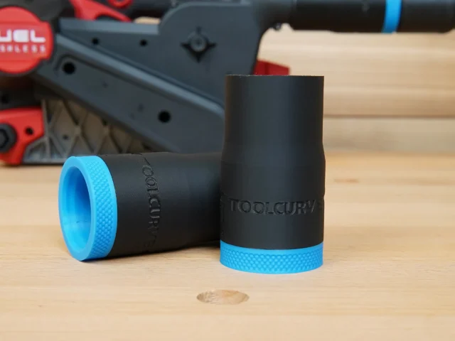 Two black hose adapters with blue grip bands, one shown upright and one laying on its side, labeled ToolCurve for Milwaukee M18 belt sander dust port connection.