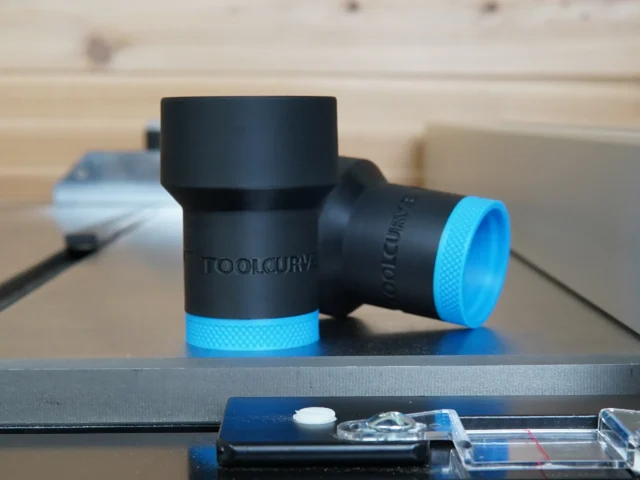 Black ToolCurve hose adapter with blue grip rings, shown as two cylindrical pieces on a work surface