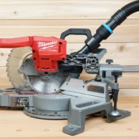 Black 1-7/8 in. hose adapter with blue band joining a vacuum hose to a Milwaukee 7-1/4 in. miter saw dust port