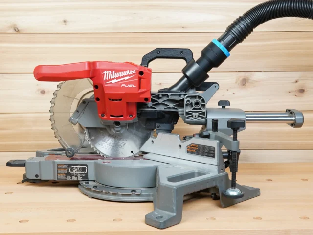 Black 1-7/8 in. hose adapter with blue band joining a vacuum hose to a Milwaukee 7-1/4 in. miter saw dust port