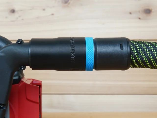 Black hose adapter with blue band attached to Milwaukee M18 belt sander dust port, connected to green and black braided hose