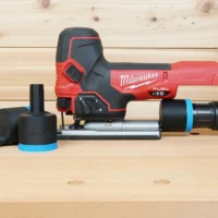 Black ToolCurve 1-7/8 inch hose adapter with blue band shown alone and fitted to a Milwaukee M18 Fuel jig saw dust port