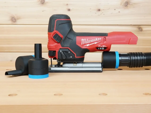 Black ToolCurve 1-7/8 inch hose adapter with blue band shown alone and fitted to a Milwaukee M18 Fuel jig saw dust port