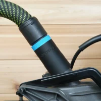 Black hose adapter with blue band attached to SKIL 10" miter saw dust port, connected to green and black Festool hose