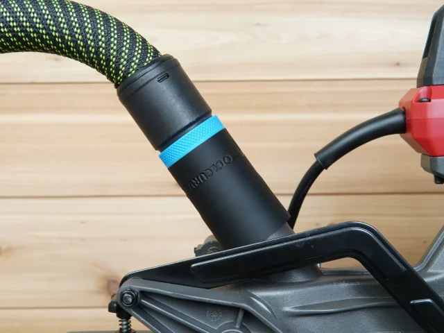 Black hose adapter with blue band attached to SKIL 10" miter saw dust port, connected to green and black Festool hose