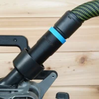 Black hose adapter with blue band attached to Milwaukee 7-1/4" cordless miter saw rear dust port, braided hose connected above
