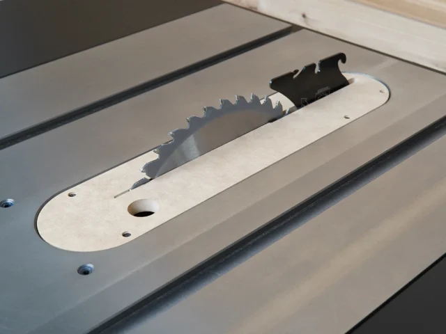 Cream MDF zero clearance insert mounted on Ridgid R4560 table saw, showing black blade guard and offset adjustment screw holes