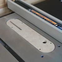 Zero clearance insert installed in Delta Contractor table saw, showing rounded MDF base with centered slot and mounting holes