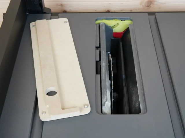 Zero clearance insert for SKIL 8-1/4" table saw, shown removed from saw table with interior openings visible, MDF construction with mounting holes and adjustment screw pocket