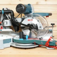 Black ToolCurve 1-1/4" hose adapter with blue band installed on a Bosch 10-inch glide miter saw dust port