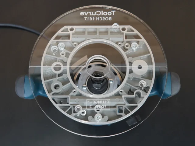 ToolCurve 8-inch round acrylic router base plate for Bosch 1617, top view showing clear acrylic with mounting holes and central router bit opening