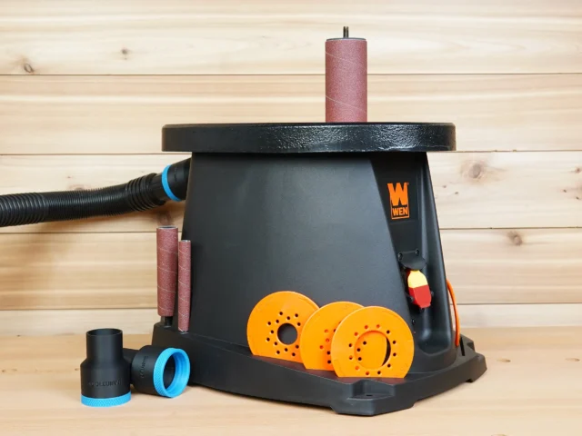 Black ToolCurve 1-7/8 inch hose adapter with blue collar beside a WEN oscillating spindle sander, one adapter connected to a dust hose
