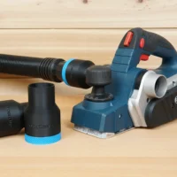 Black 1-7/8 inch hose adapter with blue trim beside a Bosch PL2632 planer, second adapter on a hose