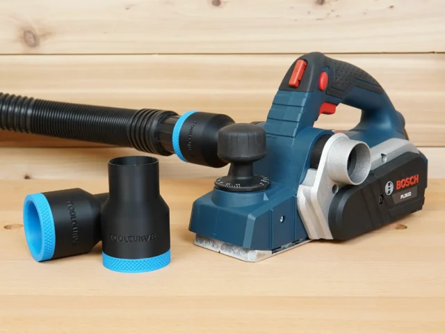 Black 1-7/8 inch hose adapter with blue trim beside a Bosch PL2632 planer, second adapter on a hose