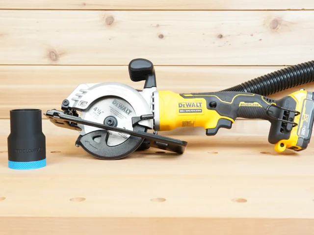 Black ToolCurve 1-7/8 inch hose adapter standing beside a Dewalt Atomic 20V 4-1/2 in. circular saw with hose attached