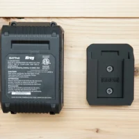 Black plastic battery mount for Kreg 18v battery, shown next to full-size Kreg BATT40 battery for scale