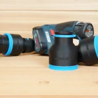 Black and blue ToolCurve 2-1/2 inch hose adapters standing beside a Bosch 12V MAX EC planer and vac hose