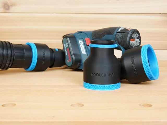 Black and blue ToolCurve 2-1/2 inch hose adapters standing beside a Bosch 12V MAX EC planer and vac hose
